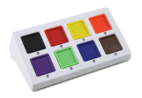Comunicatore rettangolare piatto con otto riquadri, spie luminose sotto ogni riquadro e prese per interruttori sul lato per l'accesso tramite scansione.