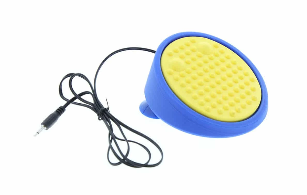 Un pulsante di forma ovale con superficie superiore testurizzata e cavo, montato su ventose.