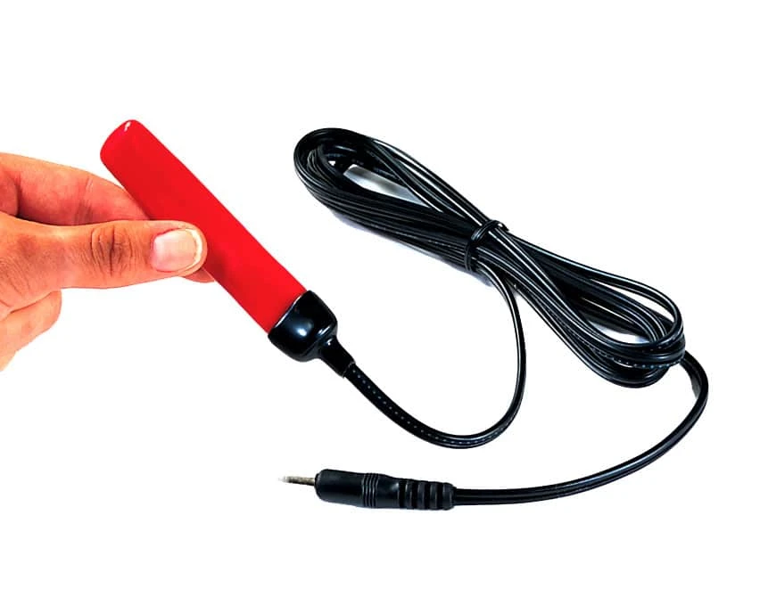 Un piccolo interruttore a pinza portatile e sottile con cavo, progettato per essere tenuto tra le dita.
