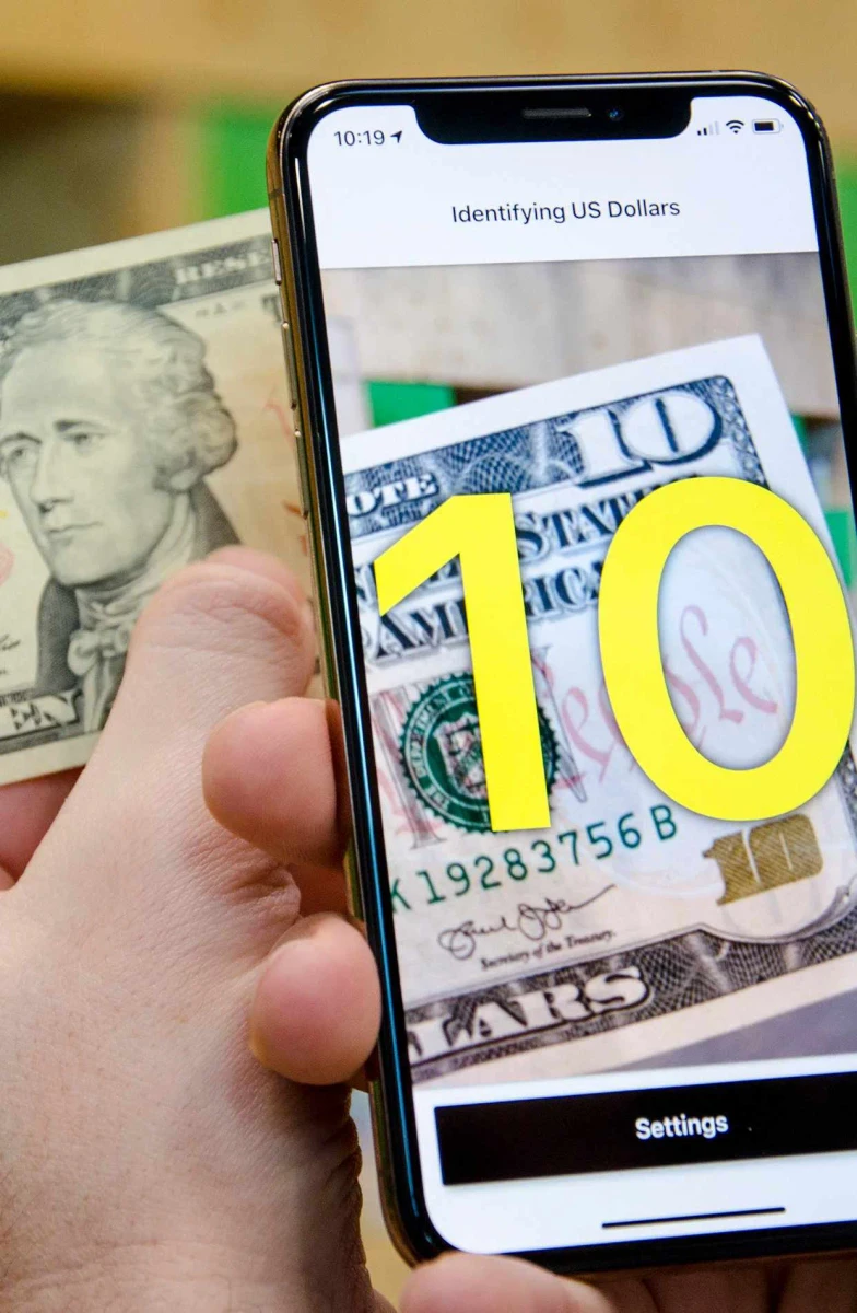 تطبيق Cash Reader يتعرّف على ورقة عشرة دولارات أمريكية ويعرض الرقم 10 بخط أصفر كبير.