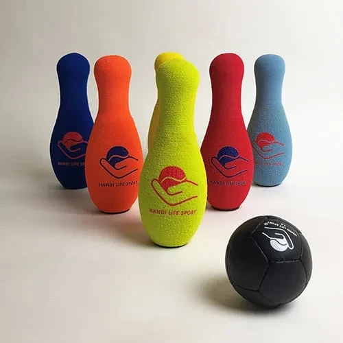 Fünf bunte Schaumstoff-Bowlingkegel mit einem schwarz handgenähten Ball.