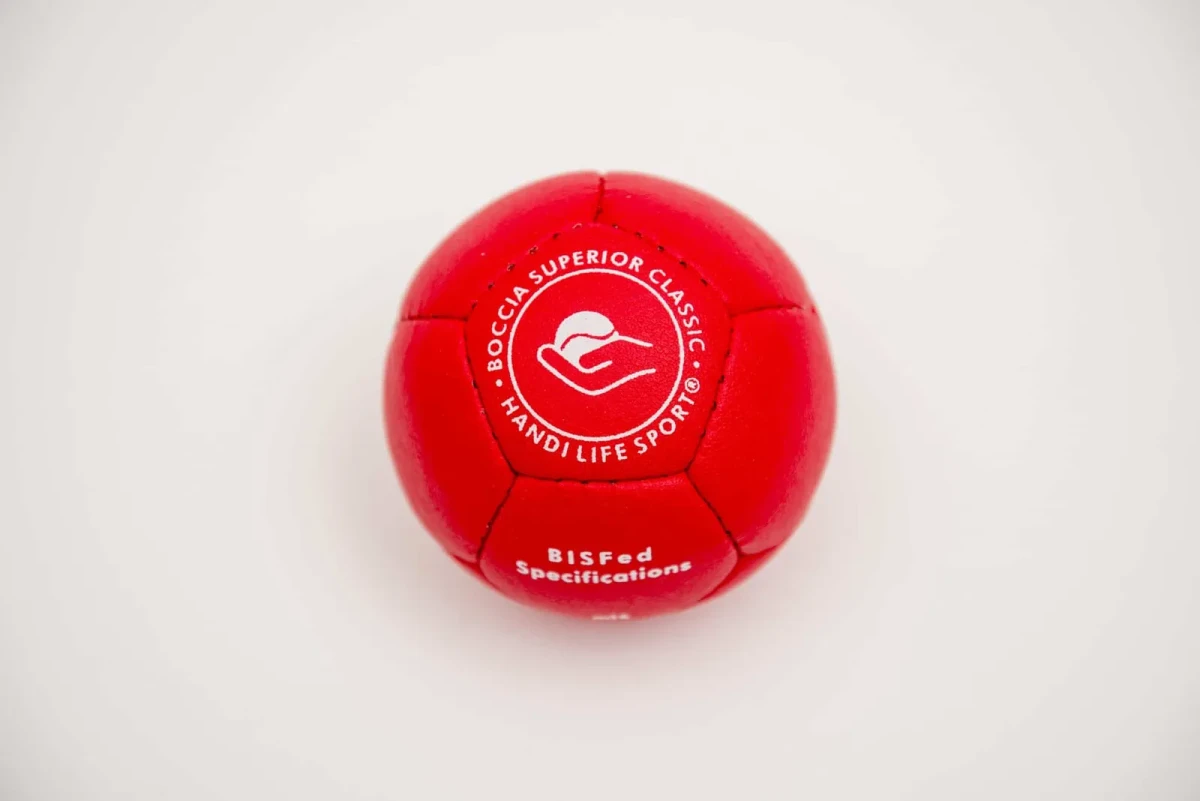 A single red leather boccia ball stamped with the Handi Life Sport logo and “Boccia Superior Classic”.