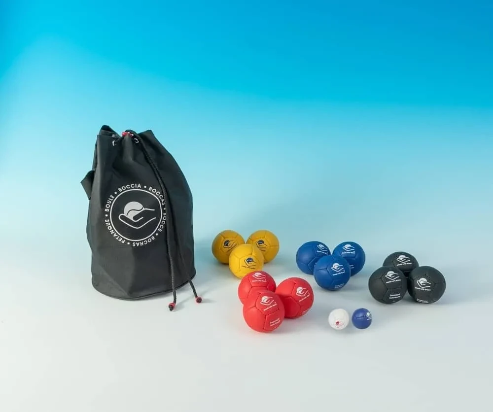 Una borsa nera con coulisse contenente bocce morbide da petanque nei colori giallo, blu, rosso e nero e due pallini bersaglio.