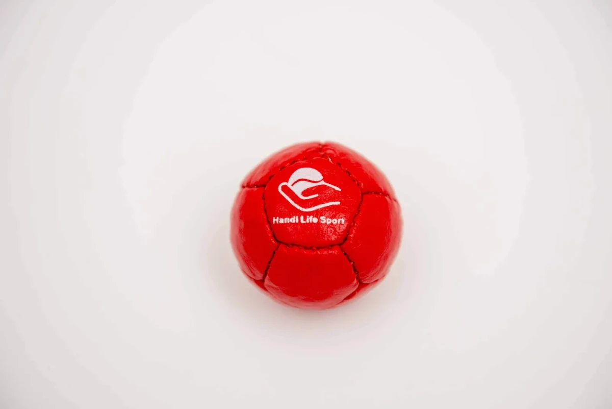 Piccolo pallino da petanque rosso in morbida pelle con il logo Handi Life Sport.