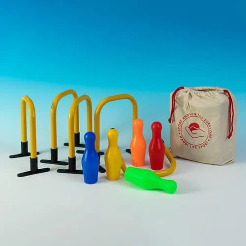 Fünf gelbe Ringe für die Füße und fünf bunte Kegel mit einer grünen Bowlingkugel und einem Baumwollbeutel.