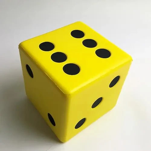 Ein großer gelber Schaumstoffwürfel mit großen schwarzen Punkten.