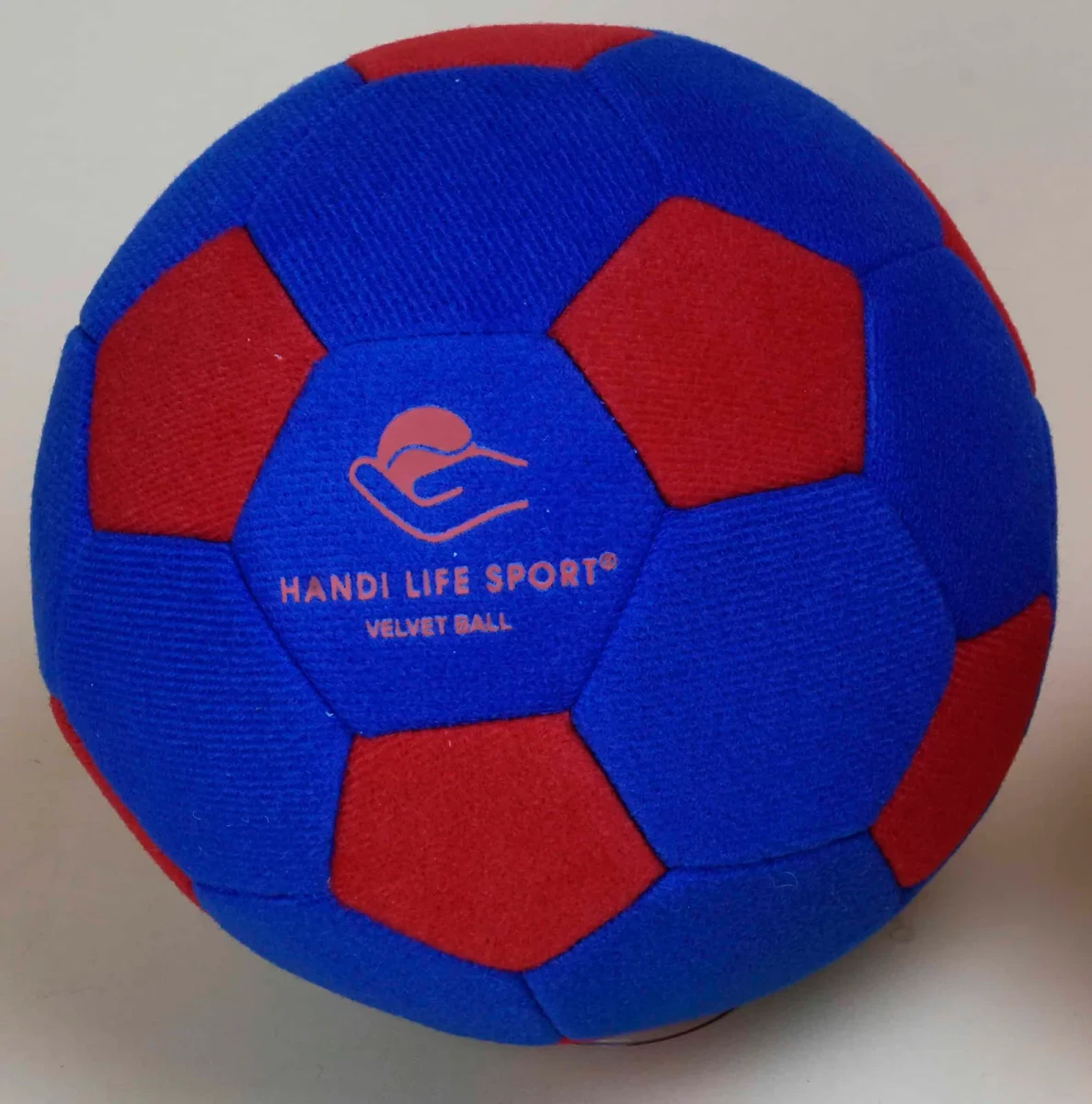 كرة مغطاة بالمخمل الناعم باللونين الأزرق والأحمر ومكتوب عليها "Velvet Ball".