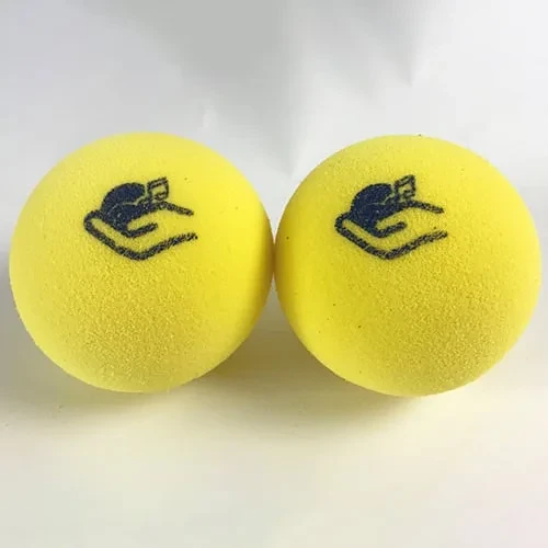 Zwei gelbe Schaumstoff-Blindentennis-Bälle mit dem Handi Life Sport Logo.