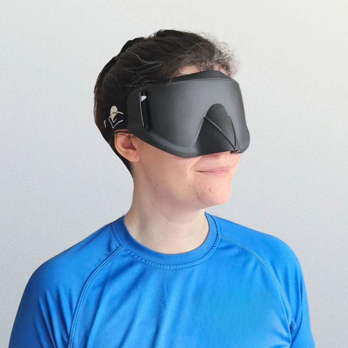 Una persona che indossa una maschera nera oscurante per sport per ciechi con protezione nasale sagomata