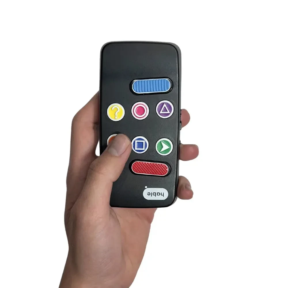 Una mano tiene il controller Hable Easy, con il pollice appoggiato su uno dei pulsanti rotondi codificati a colori, mostrando come si adatta comodamente in una mano.