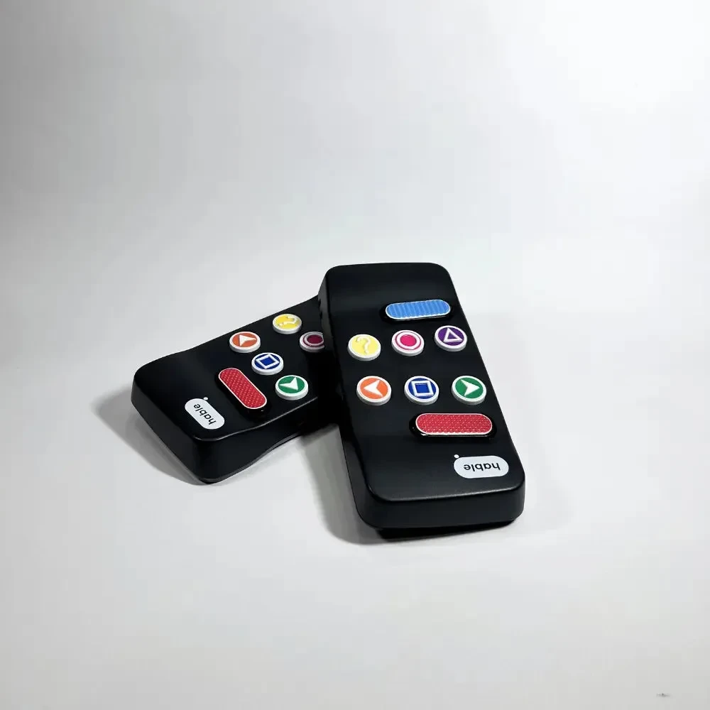 Due controller Hable Easy appoggiati l'uno contro l'altro su una superficie bianca, uno mostra i pulsanti e l'altro il retro nero liscio.