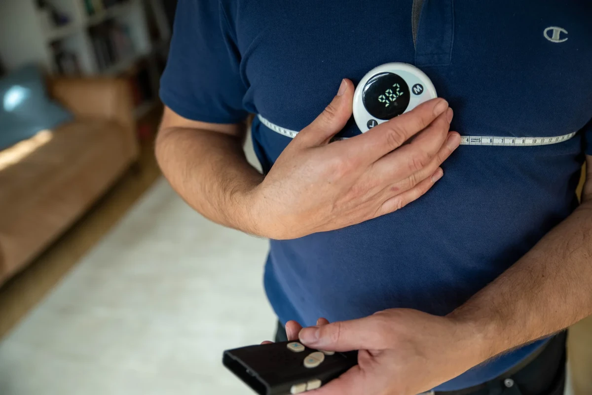 A man measuring his chest with the MT-1, holding the IKONN Controller in his other hand