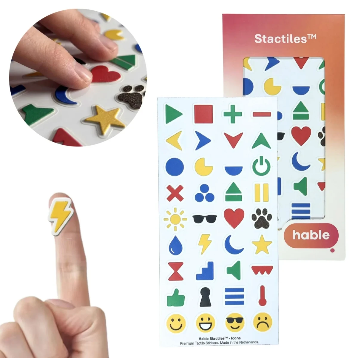 Il set Hable Stactiles Icons: un foglio bianco con 36 adesivi in rilievo di forme uniche tra cui frecce, un cerchio, un simbolo di accensione, un sole, occhiali da sole, un cuore, un'impronta di zampa, una goccia d'acqua, un fulmine, una luna, una stella, un altoparlante, un buco della serratura e faccine sorridenti, mostrato con la sua scatola arancione. Un polpastrello tiene un singolo adesivo giallo a forma di fulmine e un riquadro mostra dita che toccano le icone.