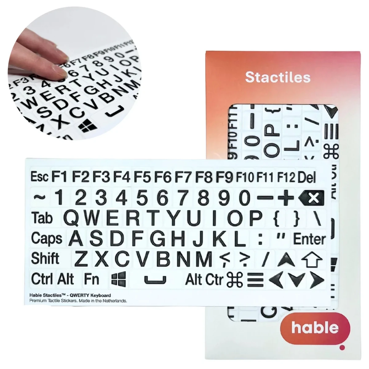 مجموعة ملصقات لوحة مفاتيح Hable Stactiles QWERTY: ورقة بيضاء تحتوي على ملصقات مفاتيح بارزة بالأسود الغامق على خلفية بيضاء تغطي لوحة مفاتيح كاملة، تشمل Esc ومفاتيح F1 إلى F12 وصف الأرقام وحروف QWERTY ومفاتيح التعديل والأسهم، معروضة أمام علبة Hable البرتقالية. تُظهر لقطة مقربة مدرجة إصبعاً يلمس المفاتيح البارزة.