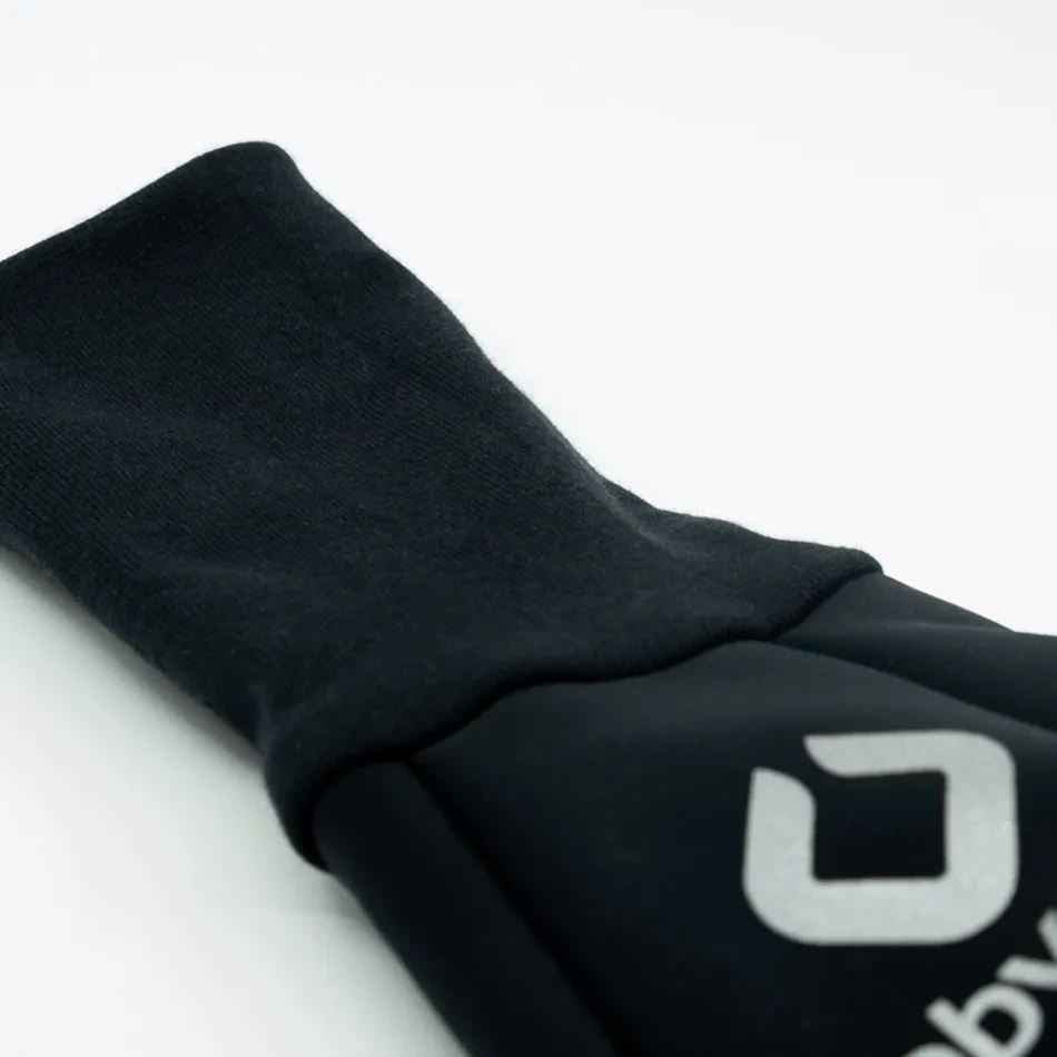 Lo scaldamano MUFF per bastone lungo: un tubo nero in softshell con bordo in cotone a coste e un fermacordino a un’estremità.