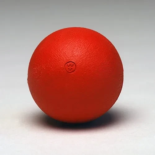 A solid orange-red rubber throwing ball with a lightly textured surface and a small moulded WV mark.